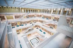 Interior of a library atrium with staircases on all sides leading down.